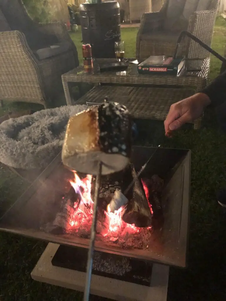 tasoting marshmallows round the firepit low lighting