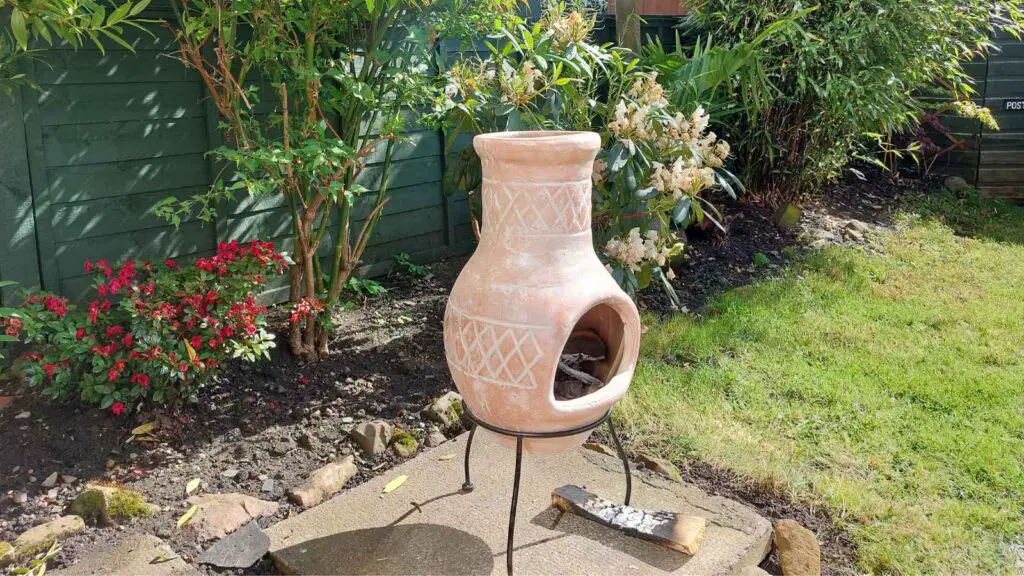 clay chiminea with a small fire